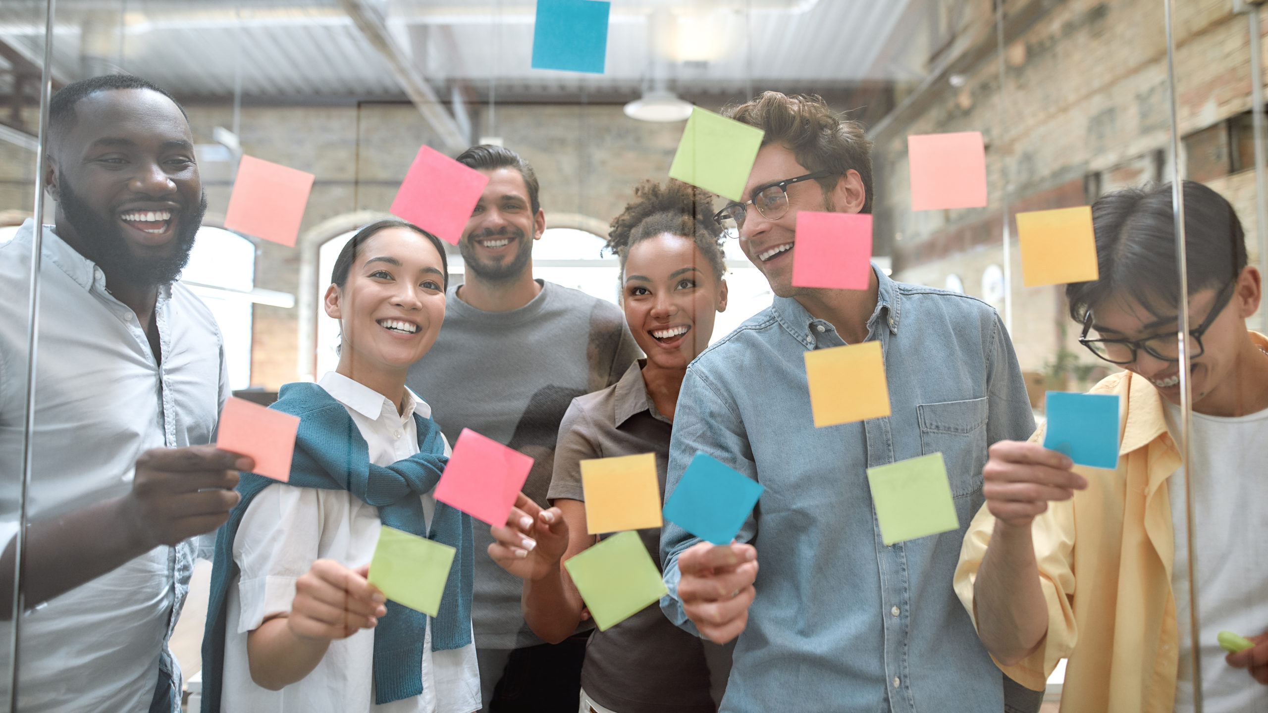 people in the workplace looking at colorful post it notes together