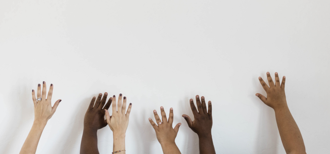 different skin colors hands raised